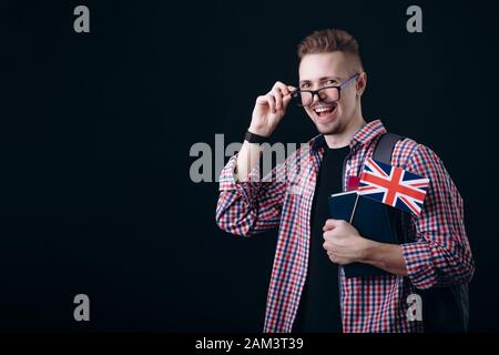 Youngster With British Flag and Books Adjusting Glasses Stock Photo