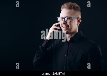 Smiling Bearded Youngster in Glasses Talking on Smartphone Stock Photo