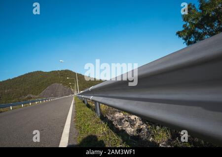 Safety steel barrier on freeway bridge designed to prevent the exit of the vehicle from the curb or bridge. Stock Photo