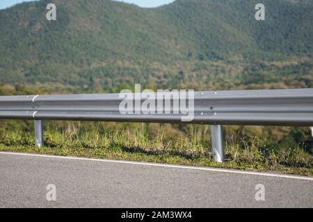 Safety steel barrier on freeway bridge designed to prevent the exit of the vehicle from the curb or bridge. Stock Photo