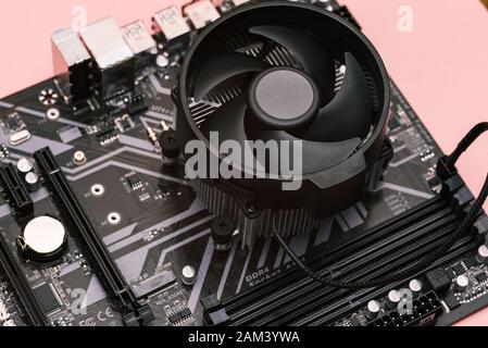 The cooling system of the processor on the computer. A cooler with a fan is installed on a computer motherboard. Electronic computer hardware technolo Stock Photo