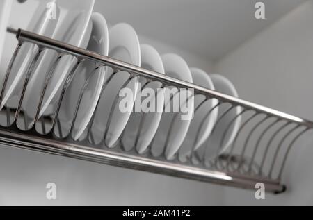 Dish drying metal rack with big nice white clean kitchenware. Traditional  wall cabinet kitchen Stock Photo by Vladdeep