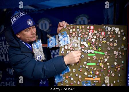 A vendor sells pin badges outside the ground before the Premier League match at Stamford Bridge, London. Stock Photo