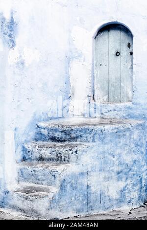 Stone staircase with old, wooden, blue door in Chefchaouen, Morocco. Stock Photo