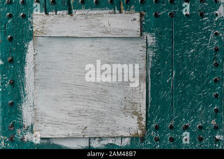 Abstract, detail of an old, mint green, wooden door with a white painted board. Texture background image with copy space. Stock Photo