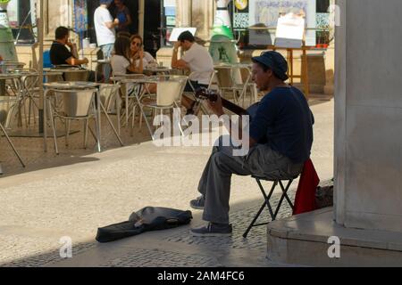 Man busking with a guitar in Rua Visconde da Luz in Coimbra Portugal Stock Photo