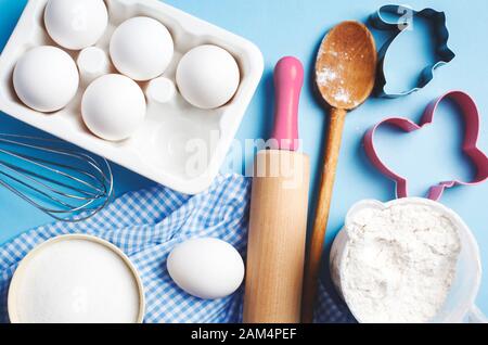 Easter baking. Ingredients and kitchen items for baking. Kitchen utensils, flour, eggs, sugar. Top view. Stock Photo