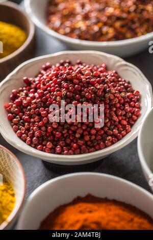 Pink peppercorn and variety spices and herbs in bowls Stock Photo