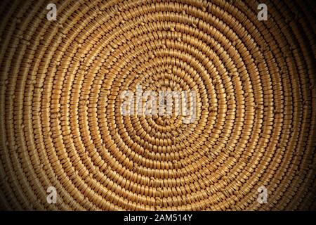 Background of a spiral woven wicker texture - Detail of a brown and orange basket Stock Photo