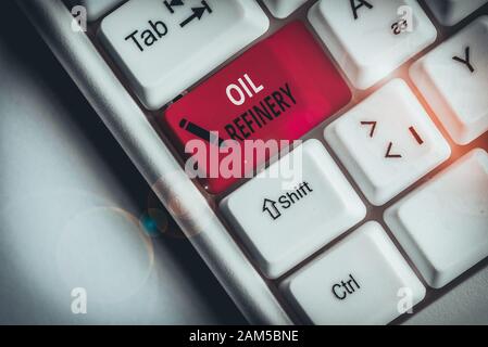 Handwriting text Oil Refinery. Conceptual photo industrial process of converting crude oil into petroleum White pc keyboard with empty note paper abov Stock Photo