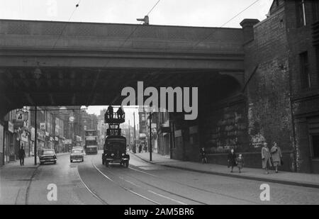 A Bedford Tower Wagon and maintenance team doing running repairs on the tram cables under the railway bridge HUL4/53 and next to the Viaduct pub, 11 Briggate City Centre, Leeds LS1 6ER. Image taken during the late 1950s before the decommissioning of the Tramway Network. The area nowadays is known as the Leeds village and popular with the LGBT community. The railway bridge was painted in the Pride colours in 2017 and also known as the Leeds Freedom Bridge. Stock Photo