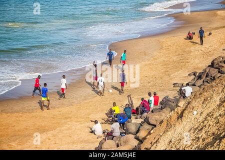 Dakar, Senegal- April 24 2019: Men playing football on the beach near Dakar city in Africa. It is the capital city of Senegal. Stock Photo