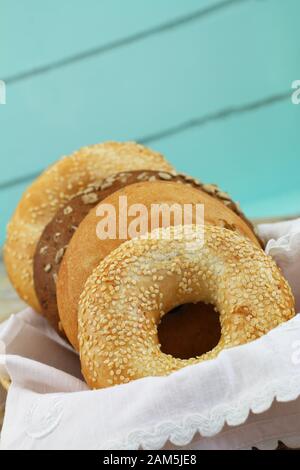 Freshly baked bagels in bread basket on blue background with copy space Stock Photo
