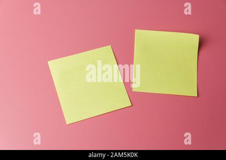 Two yellow sticky note reminders on a red background Stock Photo