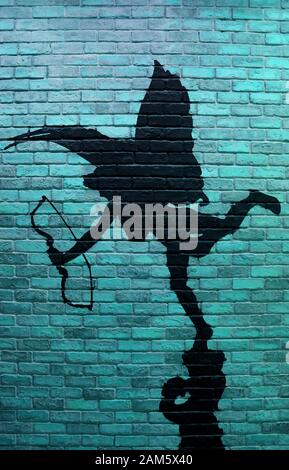 Vertical image of turquoise blue brick wall with the painting of cupid's silhouette Stock Photo