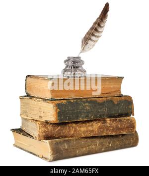 Isolated books. Glass inkwell and quill on top of old books stack isolated on white background with clipping path Stock Photo