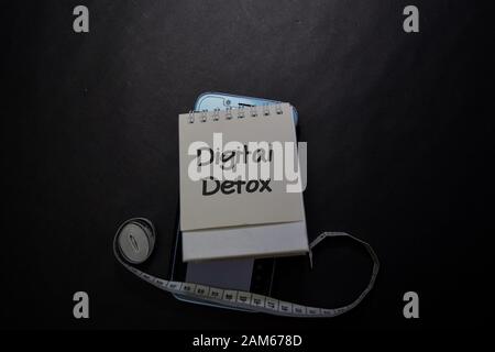 Digital Detox write on sticky note isolated on black table. Stock Photo