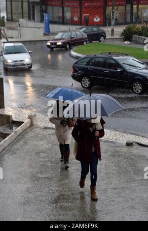 Pedestrians try to keep dry during heavy rain in Coimbra Portugal Stock Photo