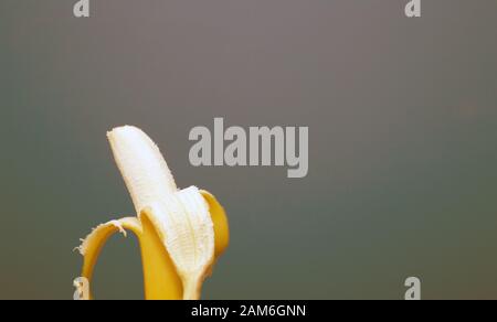 Peeled yellow banana fruit near colorful background space for text, healthy concept Stock Photo