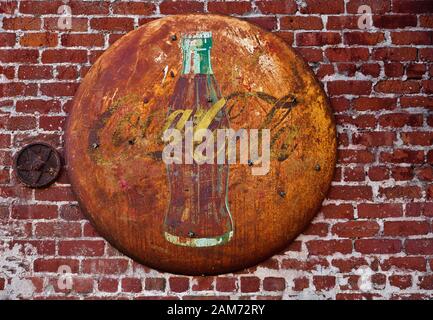 Faded rusty Coca Cola sign on red brick wall Stock Photo