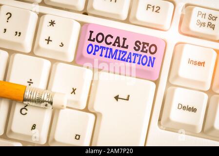Word writing text Local Seo Optimization. Business photo showcasing increase Search Visibility to Rank on Top list White pc keyboard with empty note p Stock Photo