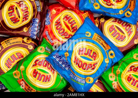 Various flavoured bags of hula hoops potato ring crisps on a counter top Stock Photo