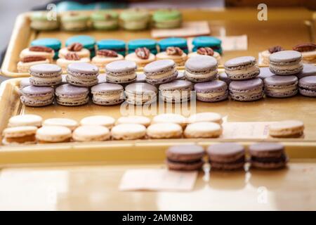 Lavander flavored purple macarons on display in a French pastry shop among other macaroons. Macaron is a traditional biscuit and cake from France, a s Stock Photo