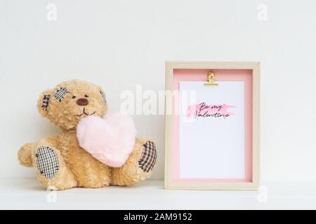 Mockup Picture frame and cute bear with pink heart. Valentines Day Background concept with copy space. Mock up with photo frame and teddy bear with sp Stock Photo