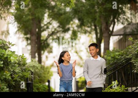 Big brother walking with his little sister. Stock Photo