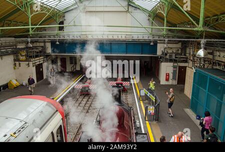 London, UK - June 22, 2019:  Vintage steam train stopped next to modern District Line train at Ealing Broadway Station marking 150th anniversary of th Stock Photo