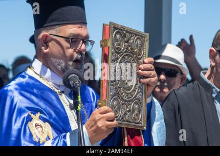 Adelaide, Australia. 12 January 2020. Greek Orthodox clergy  performs the ceremony of  the blessing of the waters on Henley pier Adelaide marking the orthodox Epiphany Day which commemorates the baptism of Jesus in the Jordan River. Credit: Amer Ghazzal/Alamy Live News Stock Photo