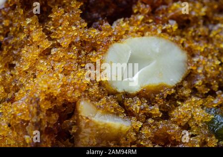 Closeup of a plum cake slice with a cut cashew nut in between. Stock Photo