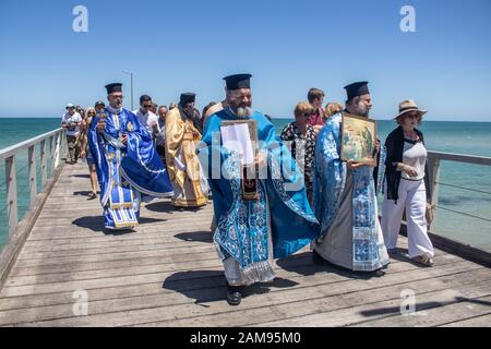 Adelaide, Australia. 12 January 2020.Greek Orthodox clergy perform the ceremony of  the blessing of the waters on Henley pier marking the orthodox Epiphany Day which commemorates the baptism of Jesus in the Jordan River. Credit: Amer Ghazzal/Alamy Live News Stock Photo