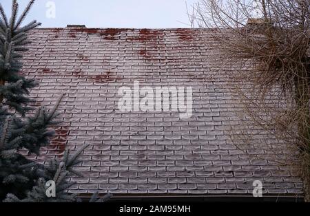 old roof covered with roofing felt during winter frosts Stock Photo
