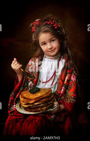 Little Girl holding pancakes. Maslenitsa Stock Photo