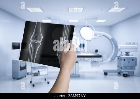 Hand holding x-ray film with 3d rendering mri scan machine or magnetic resonance imaging scan device Stock Photo
