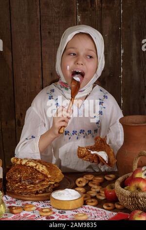 Little Girl holding pancakes. Maslenitsa Stock Photo