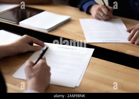 Entities holding pens put signature on legal document closeup view Stock Photo