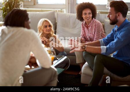 Young group of people in room talks Stock Photo