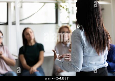 Corporate staff gathered together listening business coach at seminar Stock Photo