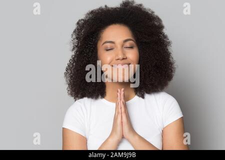 Mindful hopeful african american millennial woman praying, asking for help. Stock Photo