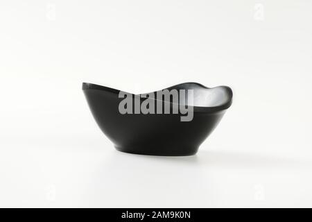 Curve black bowl for serving snacks and nuts Stock Photo
