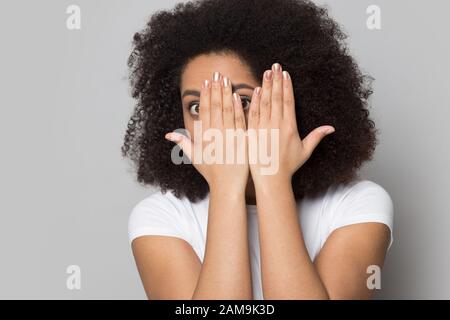Stressed worried african american young lady looking out of hands. Stock Photo