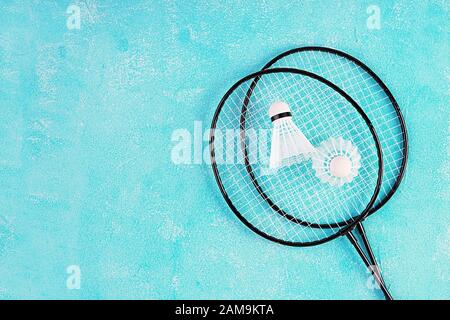 Shuttlecock and badminton rackets on a blue background. Top view Stock Photo