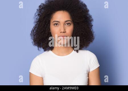 Serious focused african american millennial girl head shot studio portrait. Stock Photo