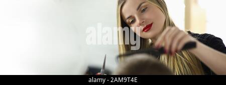 Young Woman Barber Cutting Client Hair in Salon Stock Photo