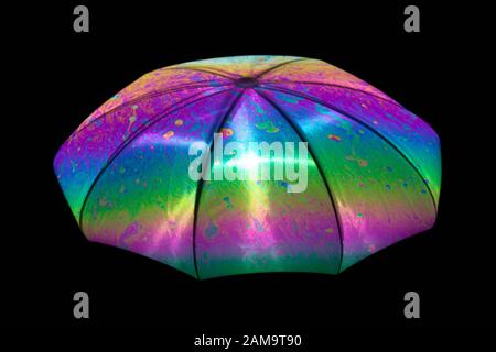 Reflection of an umbrella on the surface of a soap bubble with an interference pattern. Stock Photo