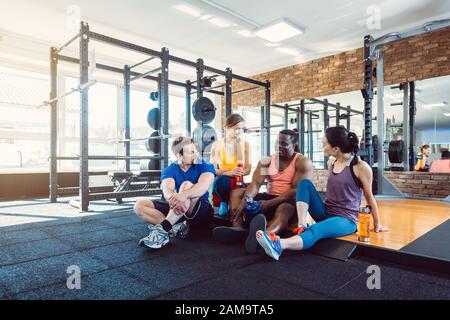 Group of women and men in gym posing at fitness training Stock Photo - Alamy