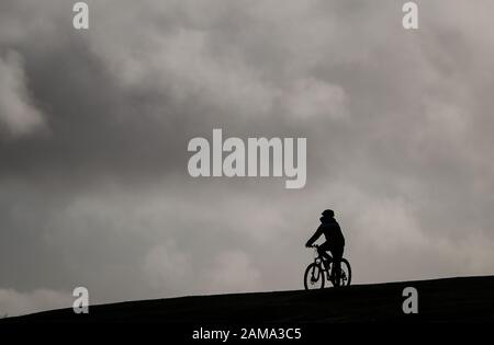 New Forest, Hampshire, UK. 12th January 2020. UK Weather: Rain clouds gather over Bolton’s Bench in Lyndhurst in the New Forest as a cyclist make his way up the hill. Credit: Stuart Martin/Alamy Live News Stock Photo