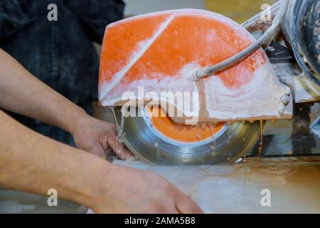 Cutting tiles using a diamond blade saw worker use wet sawing machine for cutting Stock Photo